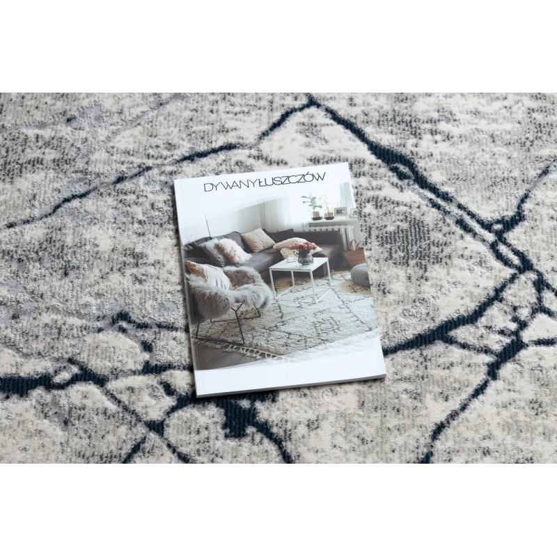 Tapis moderne REBEC dans des tons crème et bleu foncé, parfait pour les intérieurs contemporains